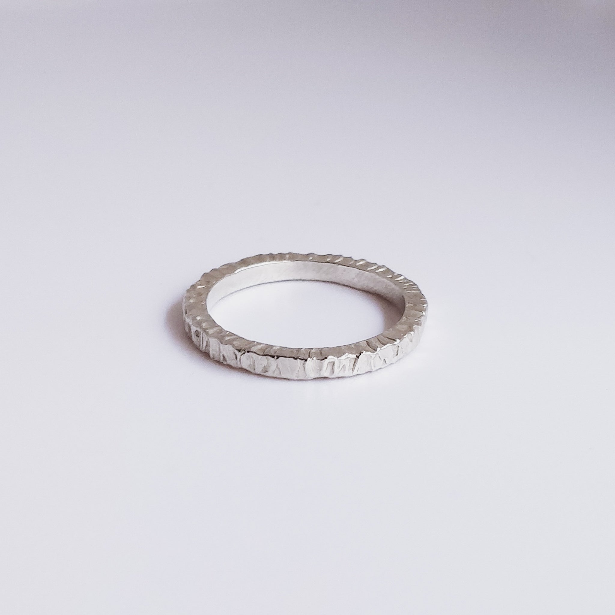 mountain inspired textured sterling silver ring on a white surface 