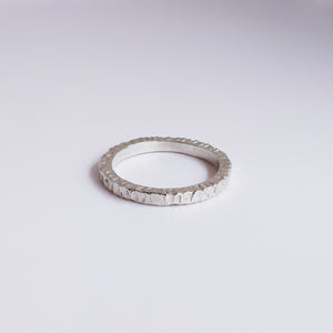 mountain inspired textured sterling silver ring on a white surface 